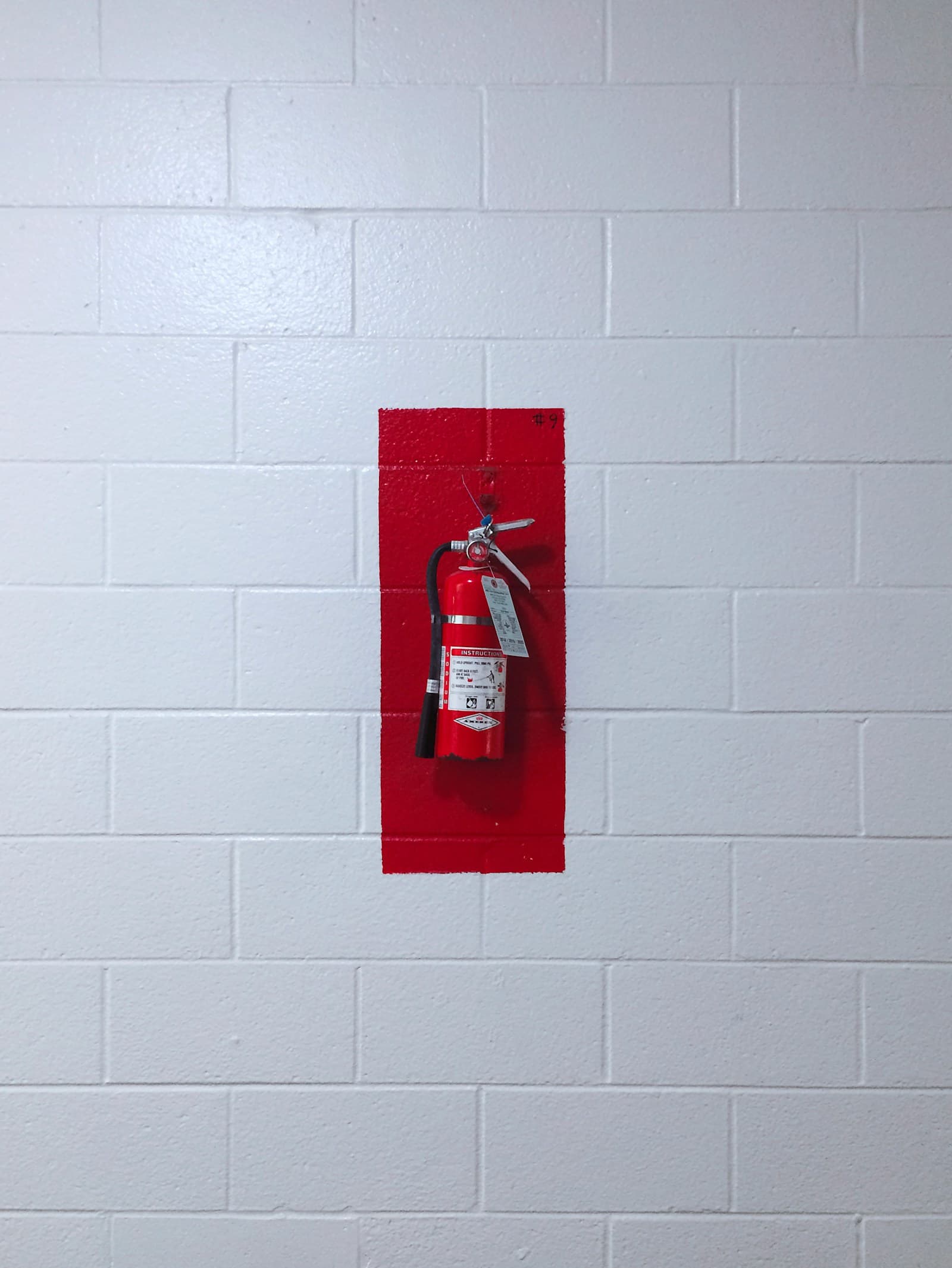 Red fire extinguisher mounted on a wall